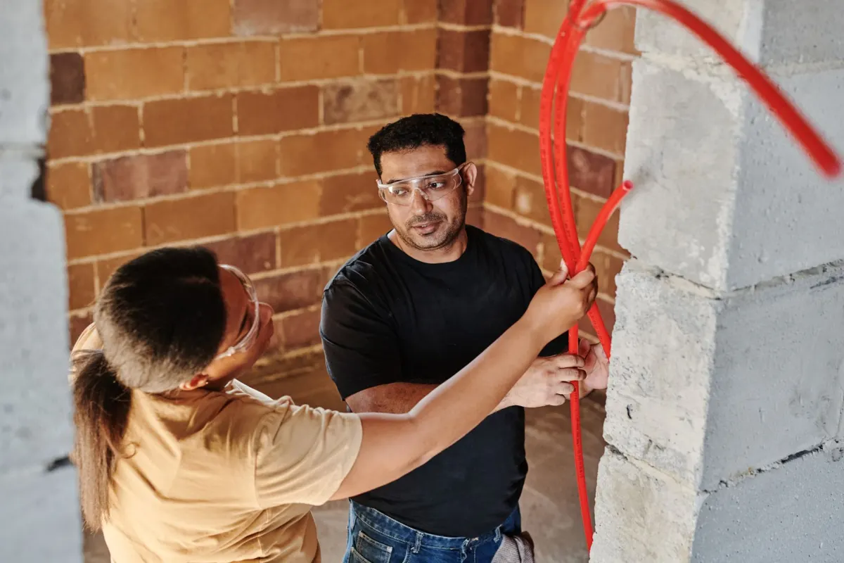 Artisans installant une tuyauterie lors d'un chantier de rénovation