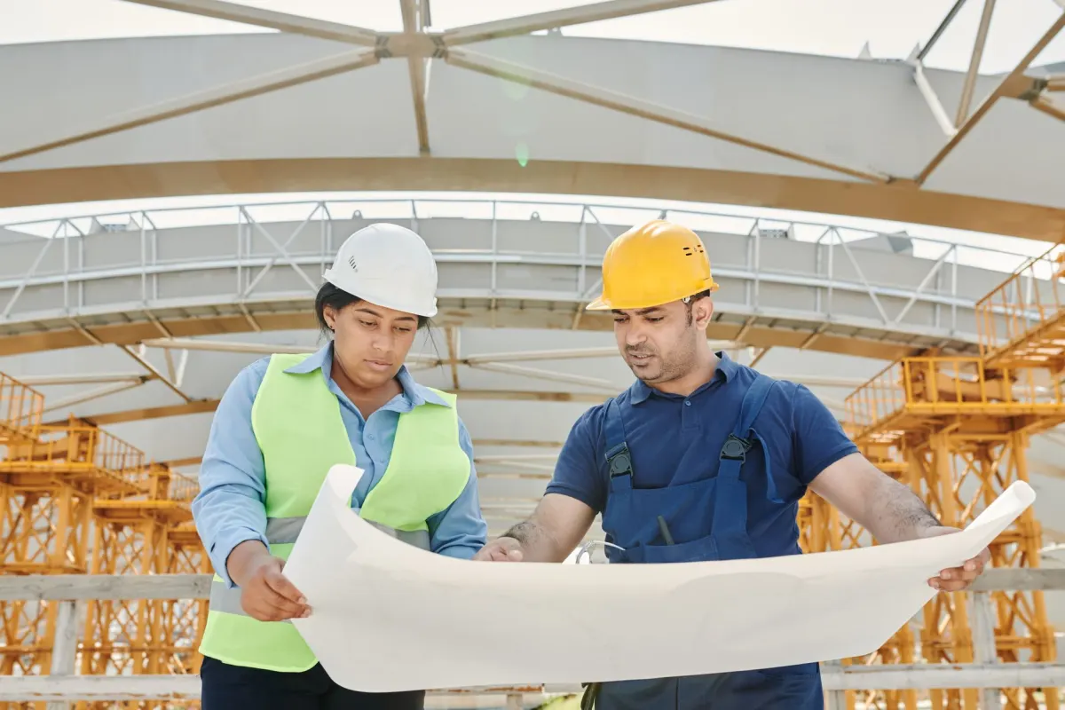 Professionnels du bâtiment consultant un plan sur un chantier de construction