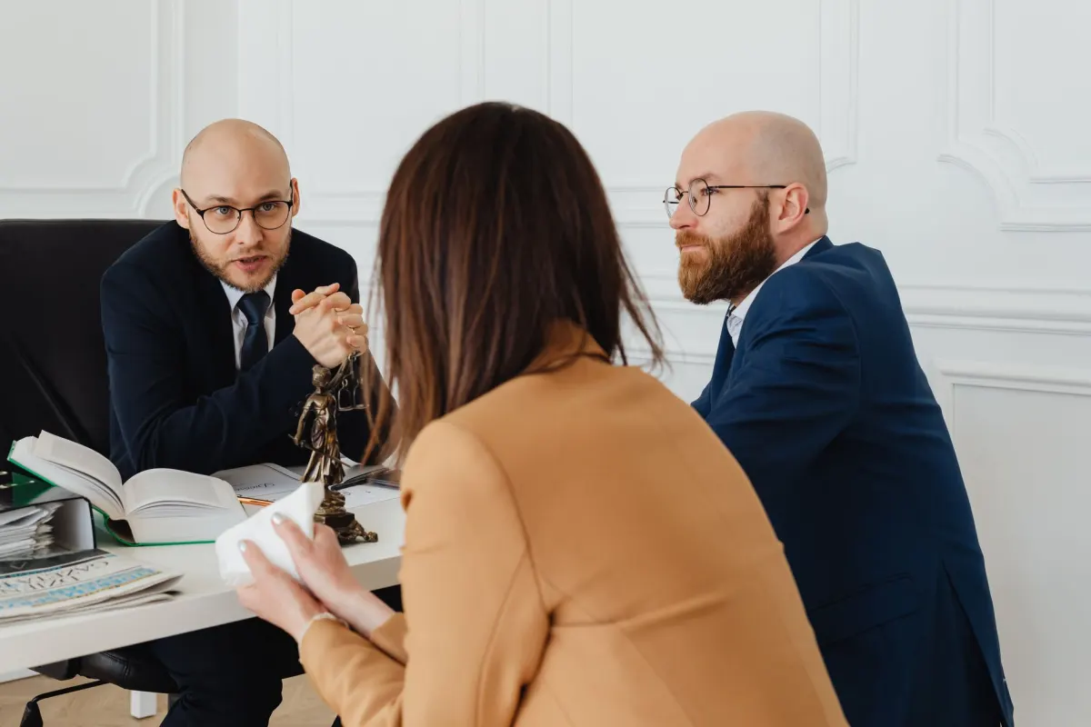 Avocats en réunion de conseil avec une cliente dans un cabinet