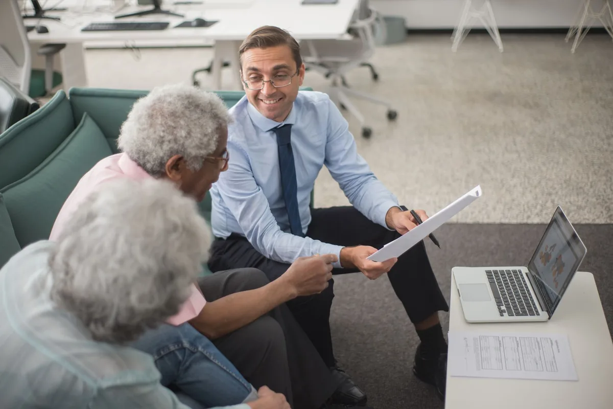 Conseiller en gestion de patrimoine échangeant avec un client dans son bureau