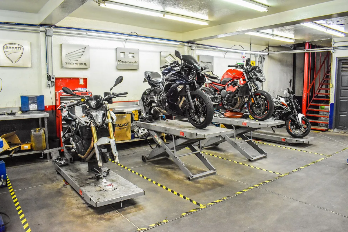 Mécanicien réparant une moto sur l'établi d'un garage spécialisé deux-roues