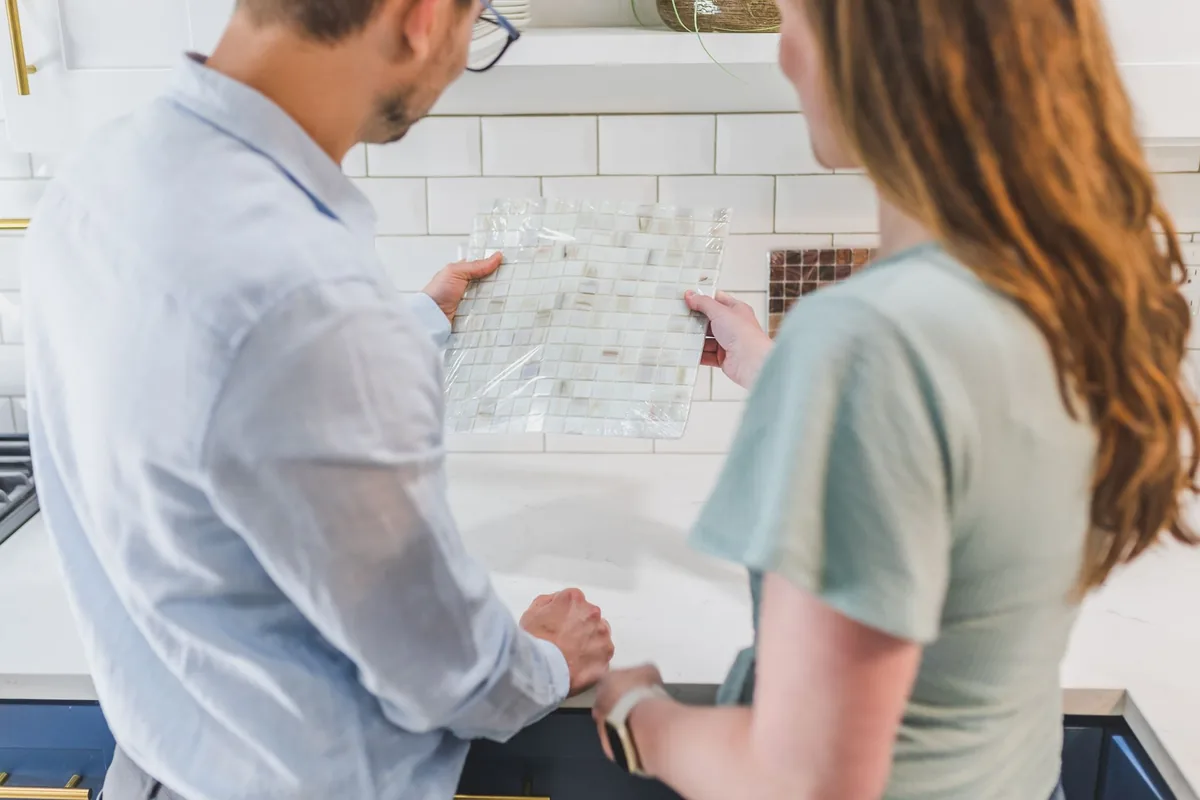 Couple choisissant des carreaux de crédence pour la rénovation de sa cuisine