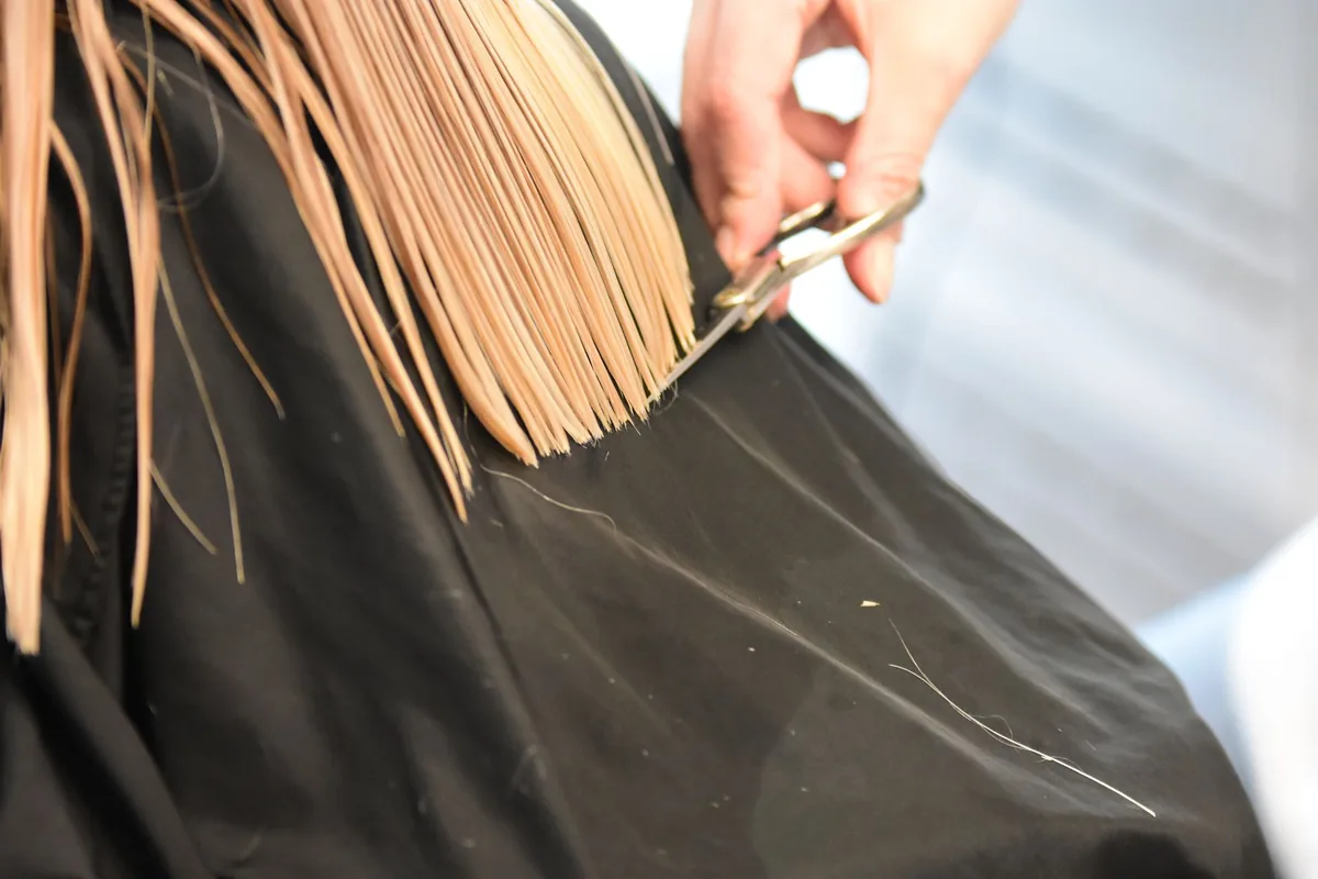 Coiffeur réalisant une coupe de cheveux à sa cliente dans un salon