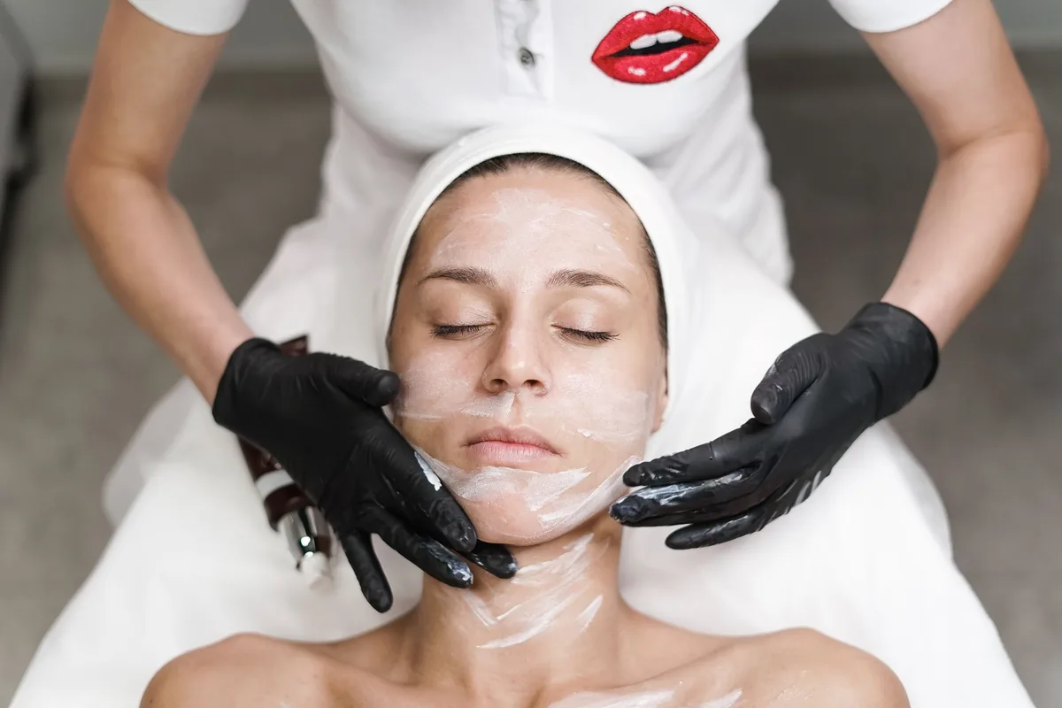 Esthéticienne réalisant un soin du visage à une cliente en institut de beauté