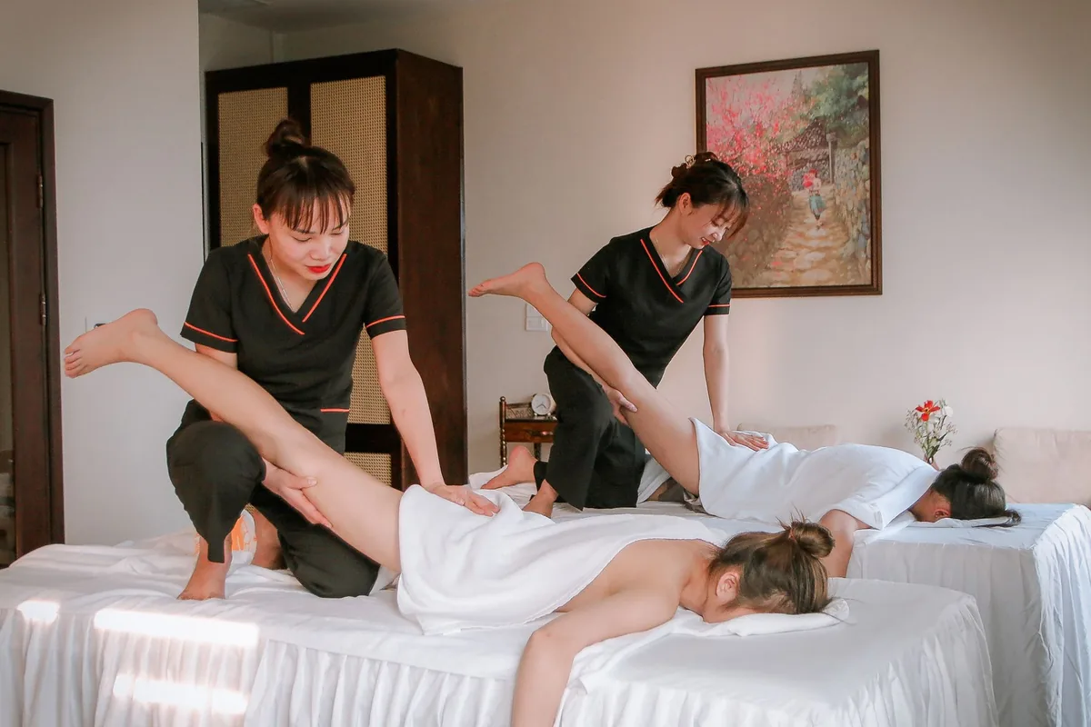 Praticienne de spa prodiguant un massage relaxant à une cliente