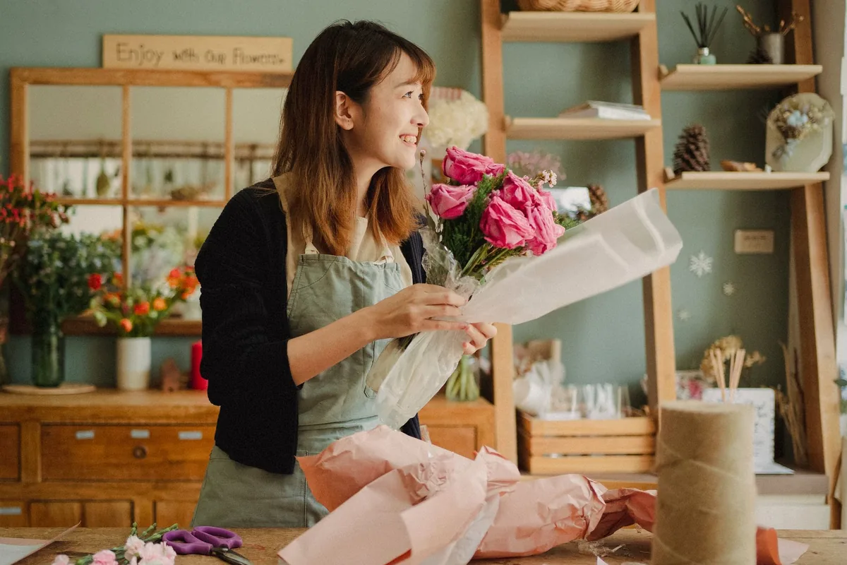 Fleuriste préparant un bouquet de fleurs fraîches dans sa boutique