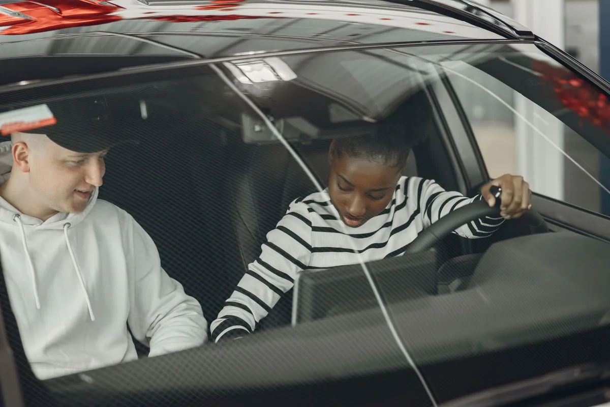 Moniteur d'auto-école assis aux côtés de son élève pendant une leçon de conduite en circulation