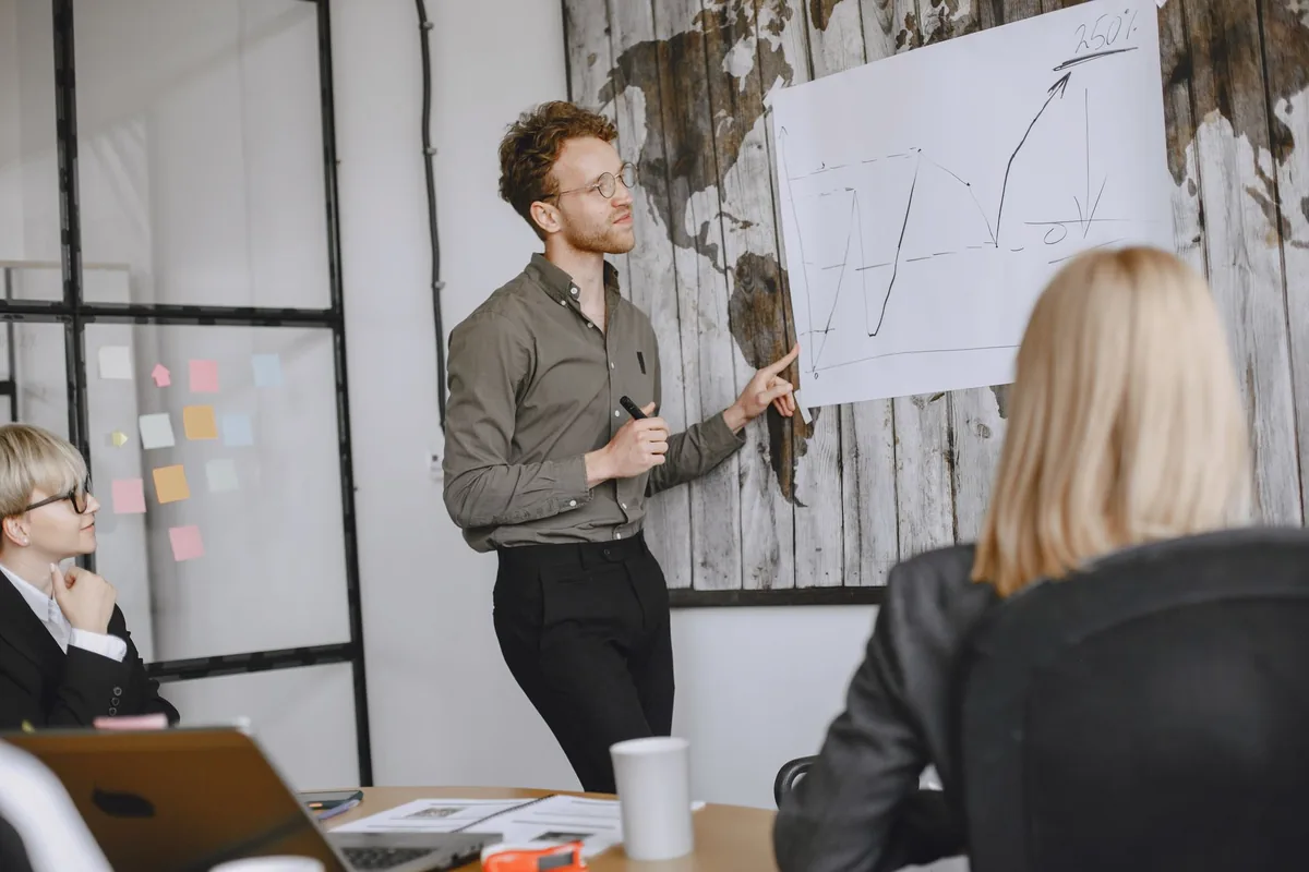 Formateur animant une session de formation professionnelle devant un groupe d'adultes en entreprise