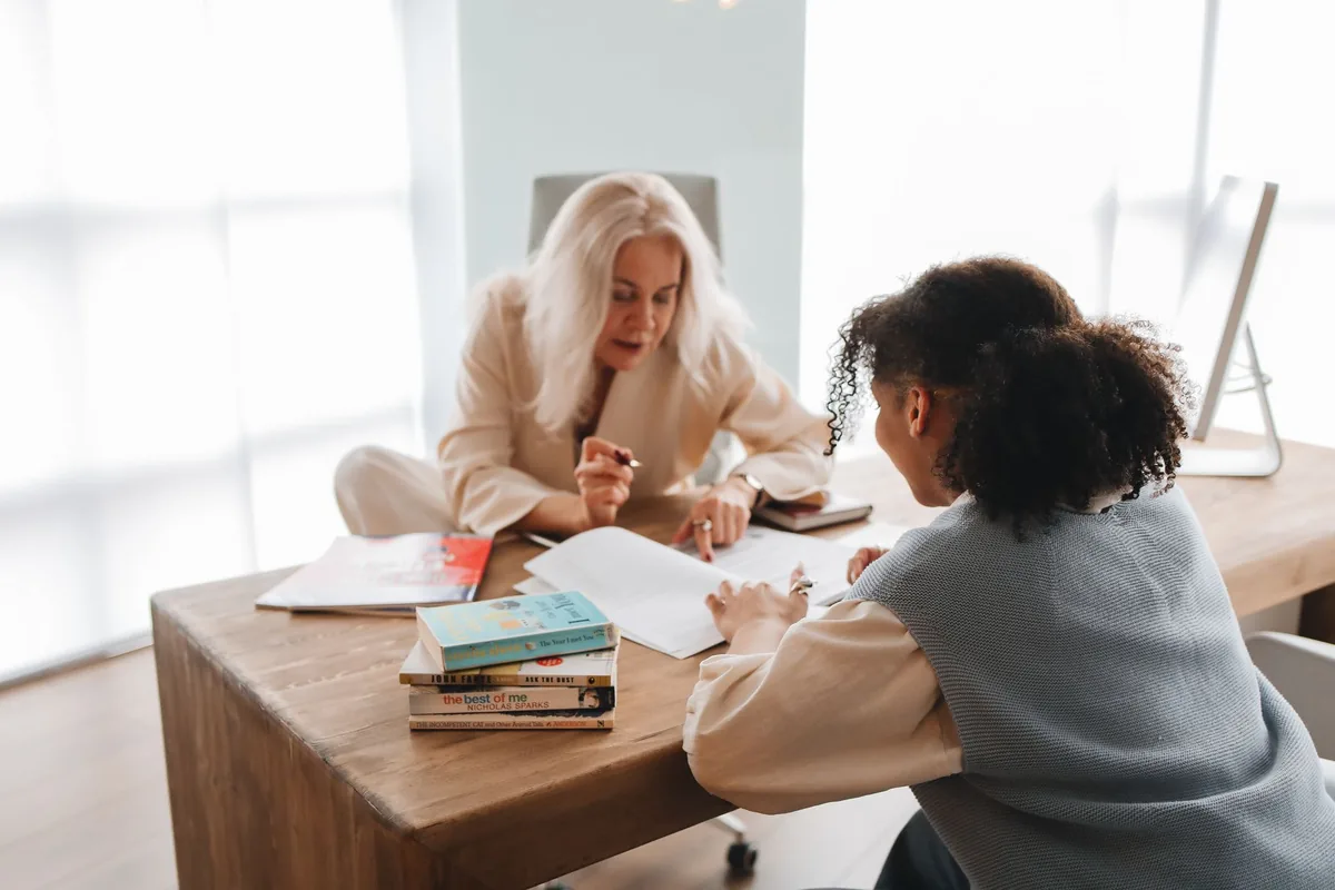 Professeur particulier donnant un cours de soutien scolaire à un adolescent à la table de la cuisine