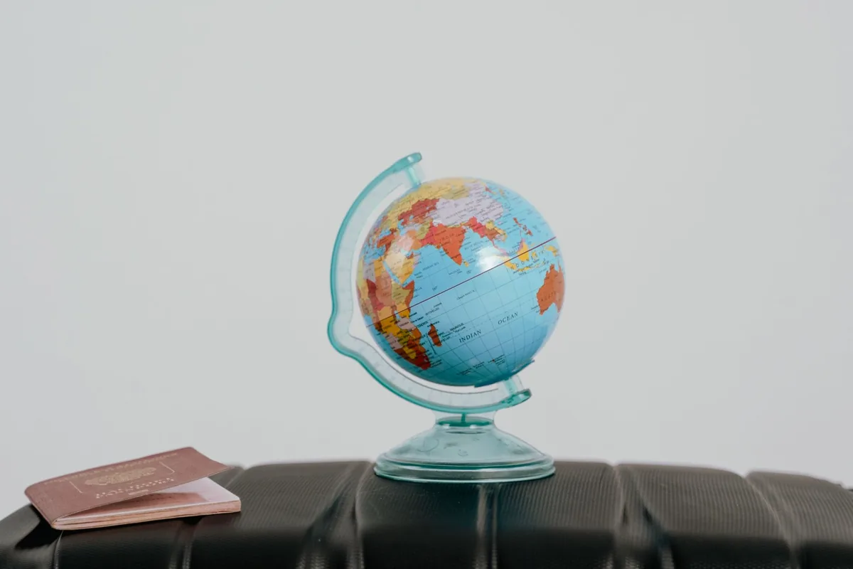 Globe et passeport posés sur une valise, symboles de préparation de voyage