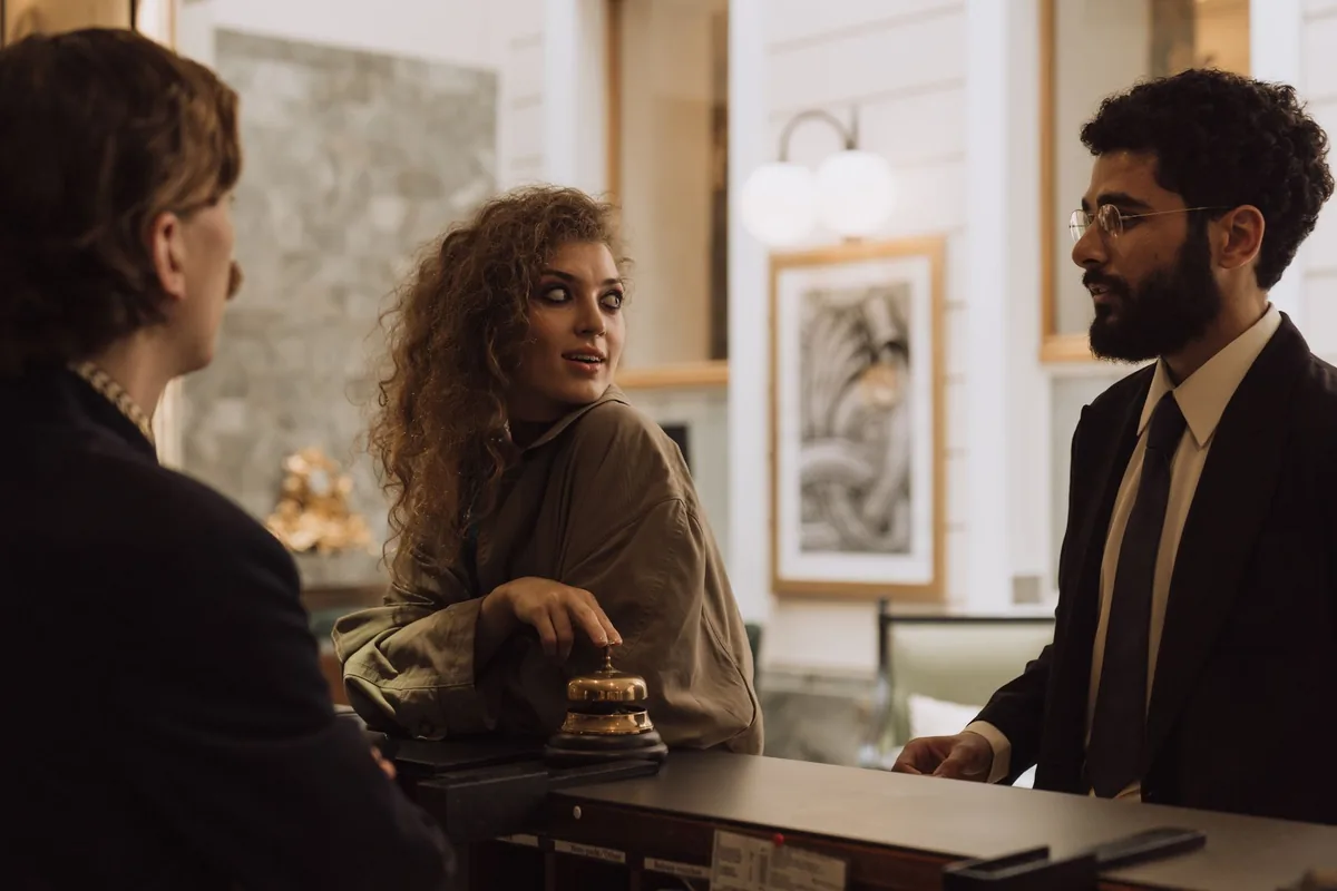 Réceptionniste d'hôtel accueillant un client au comptoir de réception