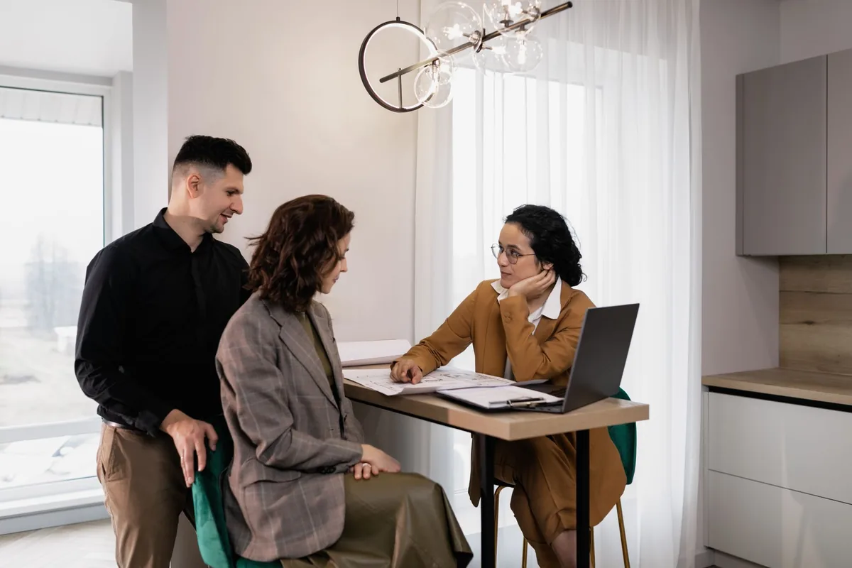 Agent immobilier en agence recevant un client pour discuter de son projet