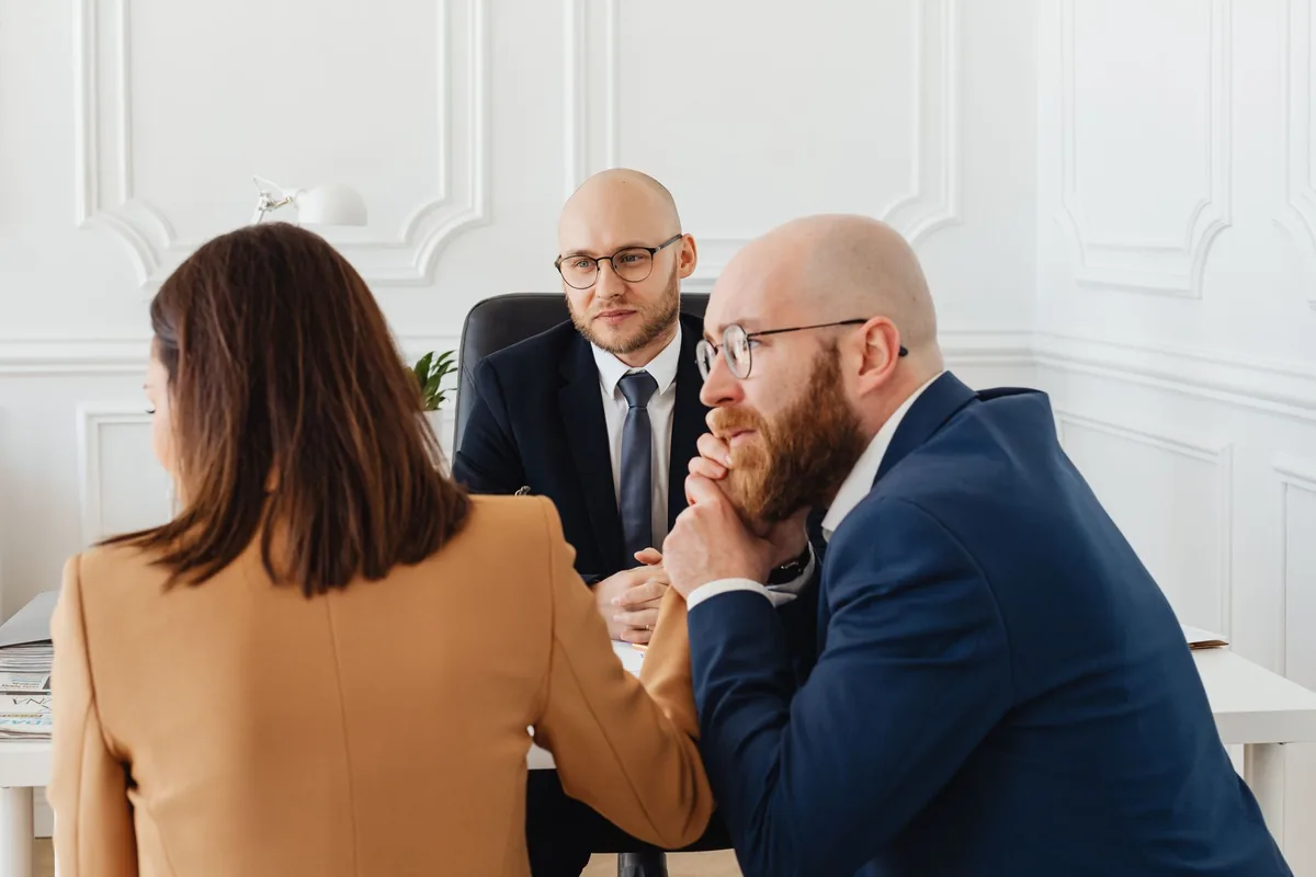 Consultant échangeant avec un client autour d'une table de réunion