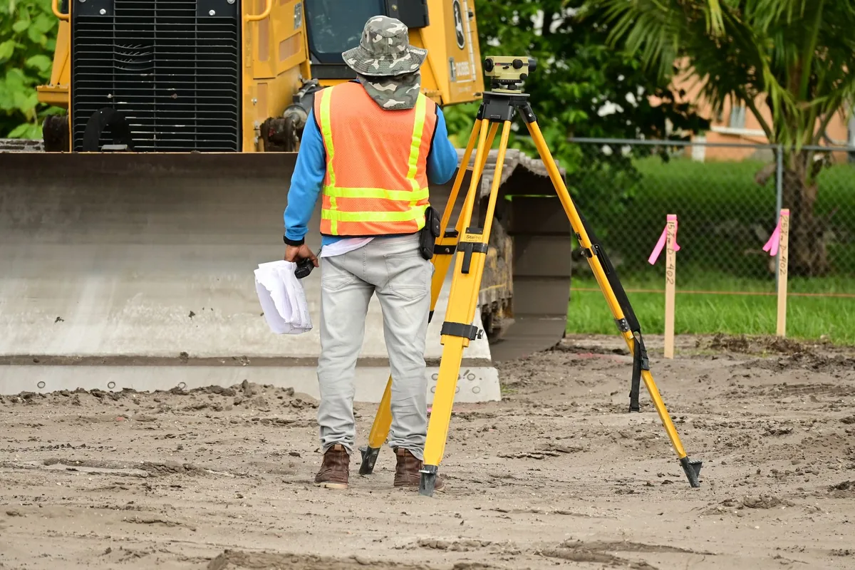 Géomètre-expert réalisant un relevé de terrain sur un chantier