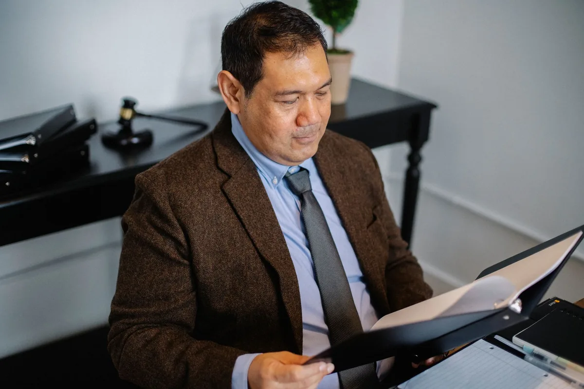 Commissaire de justice consultant un dossier dans son étude