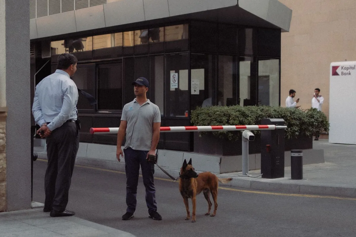 Agent de sécurité avec chien de garde contrôlant l'accès à l'entrée d'un bâtiment
