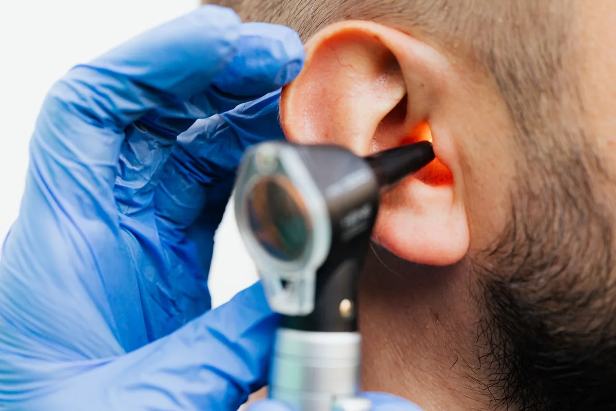 Audioprothésiste ajustant un appareil auditif pour un patient