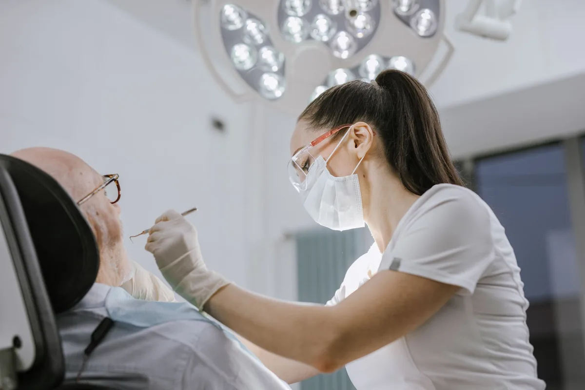 Dentiste examinant le sourire d'un patient dans son cabinet