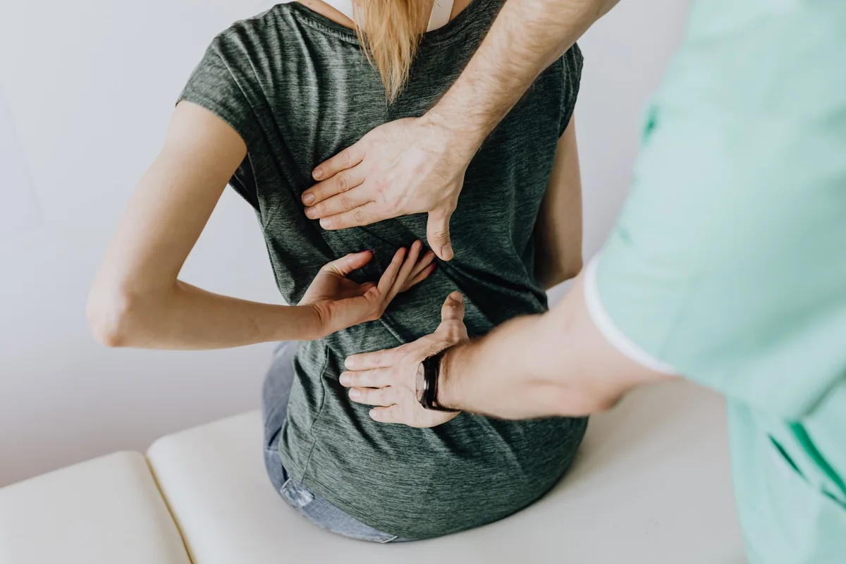 Ostéopathe manipulant le dos d'un patient allongé sur la table