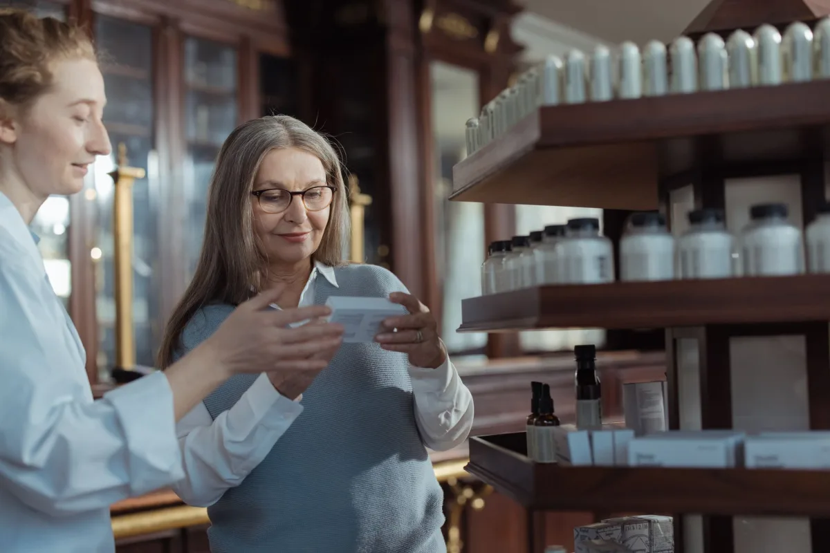 Pharmacienne conseillant une cliente au comptoir de son officine
