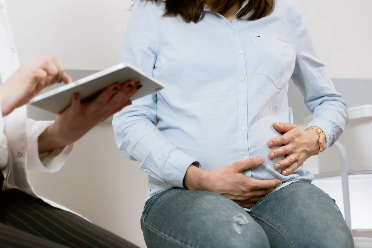 Sage-femme en consultation de suivi avec une femme enceinte