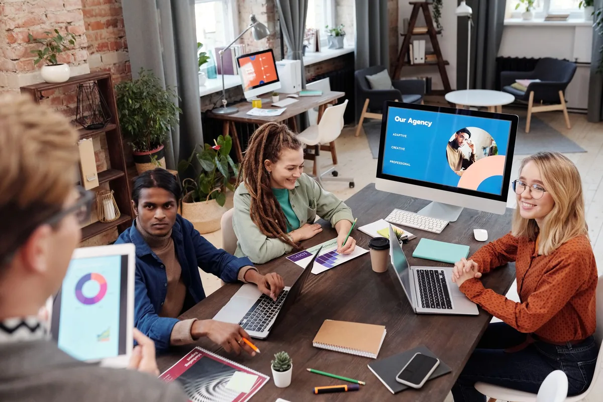 Équipe d'une agence de services accueillant des clients dans ses bureaux