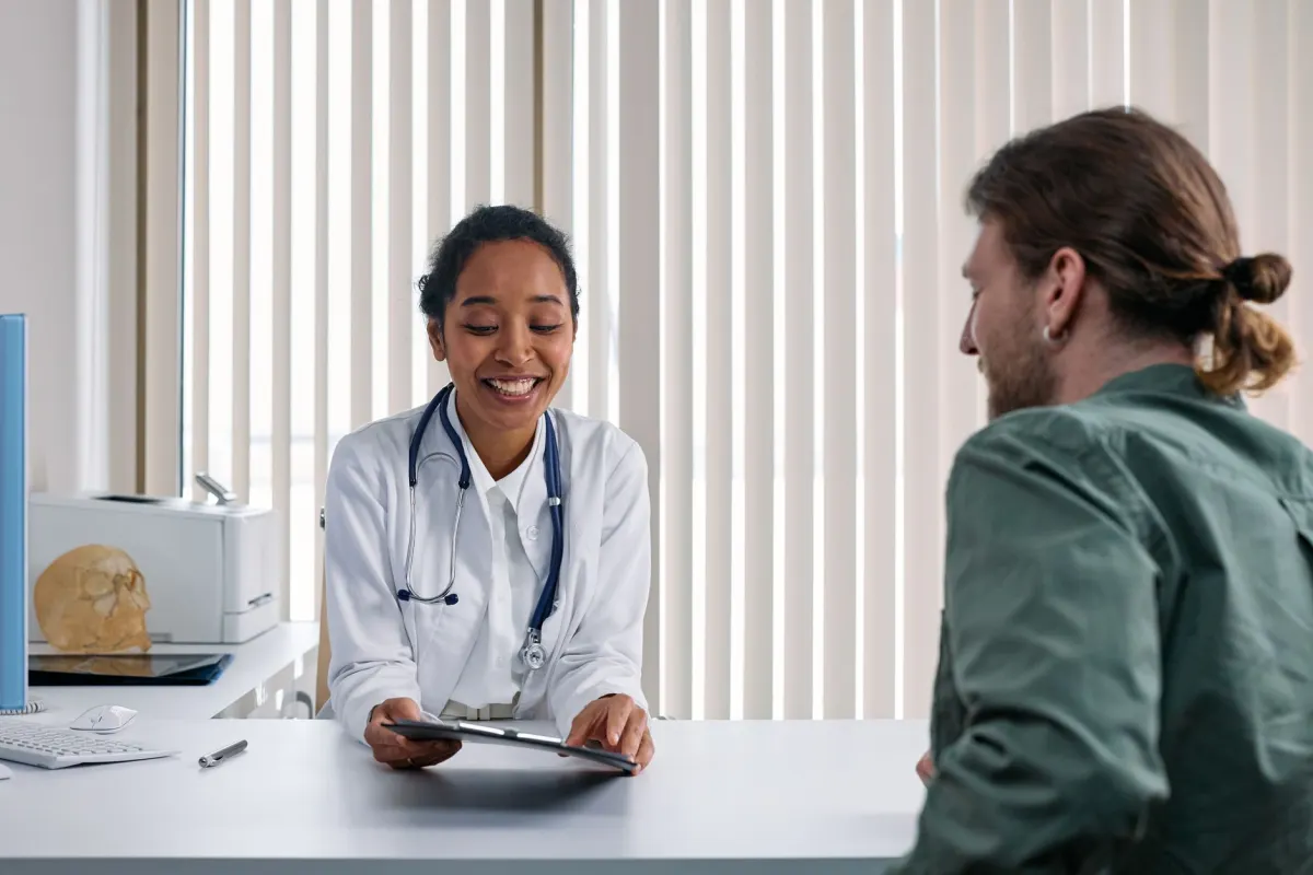 Médecin souriante consultant un patient dans son cabinet